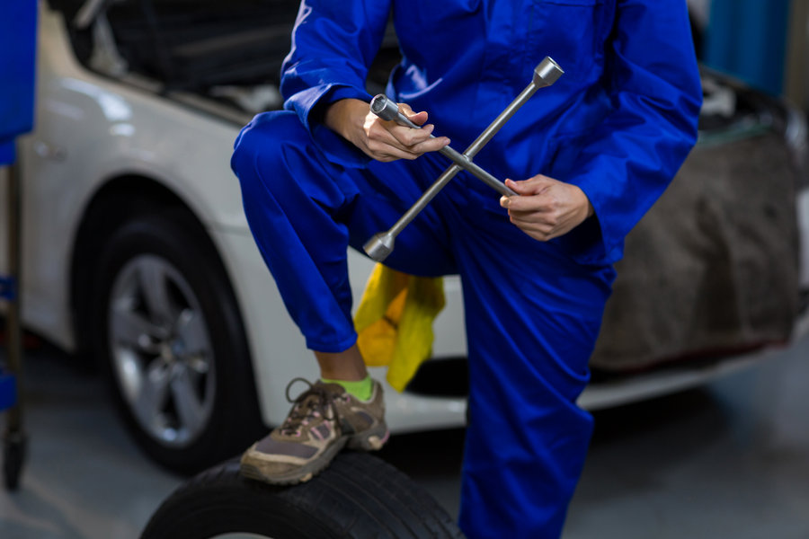 mid-section-female-mechanic-with-lug-wrench.jpg